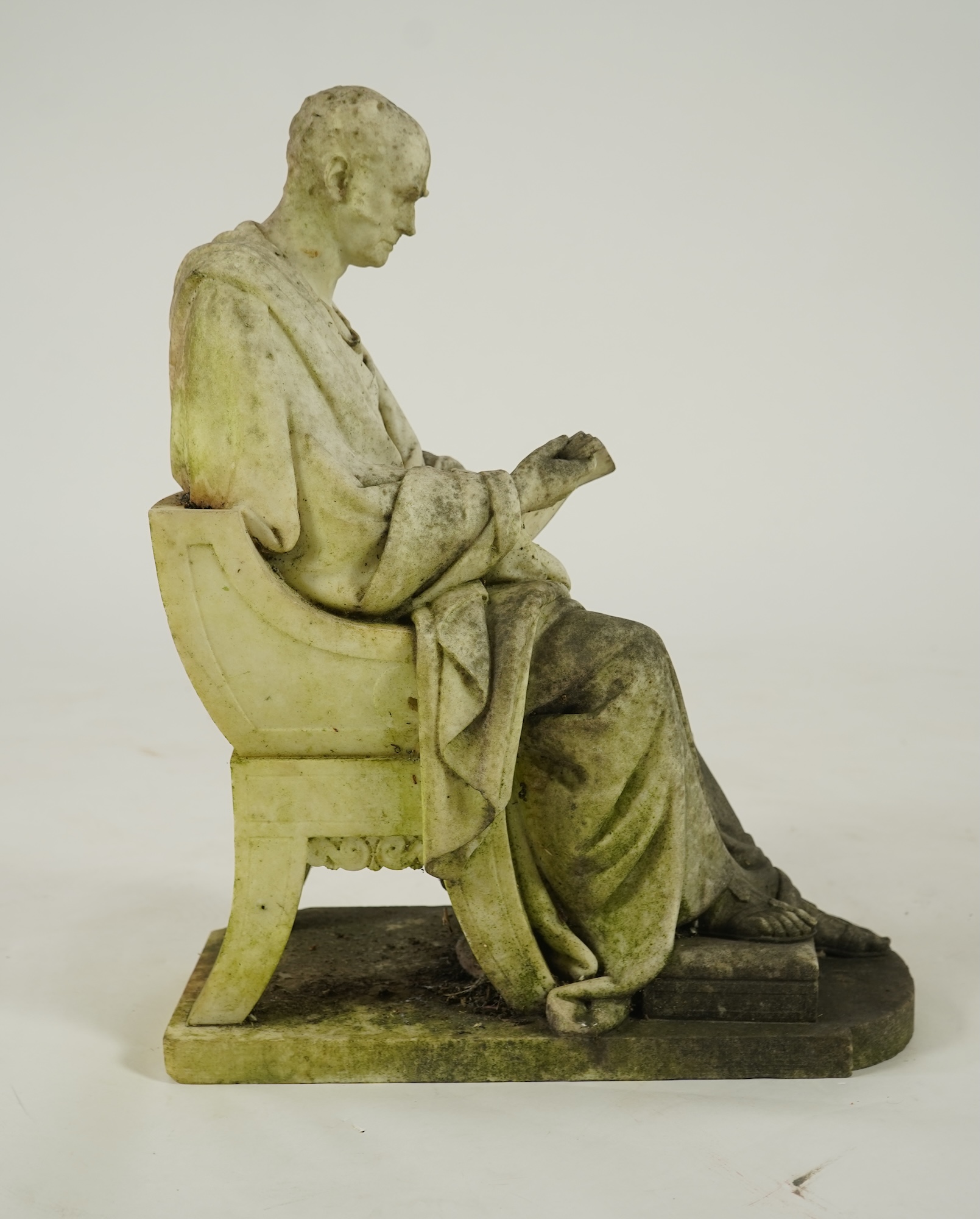 A marble sculpture of a gentleman dressed as a Greek philosopher, seated in a klismos chair, first half 19th century